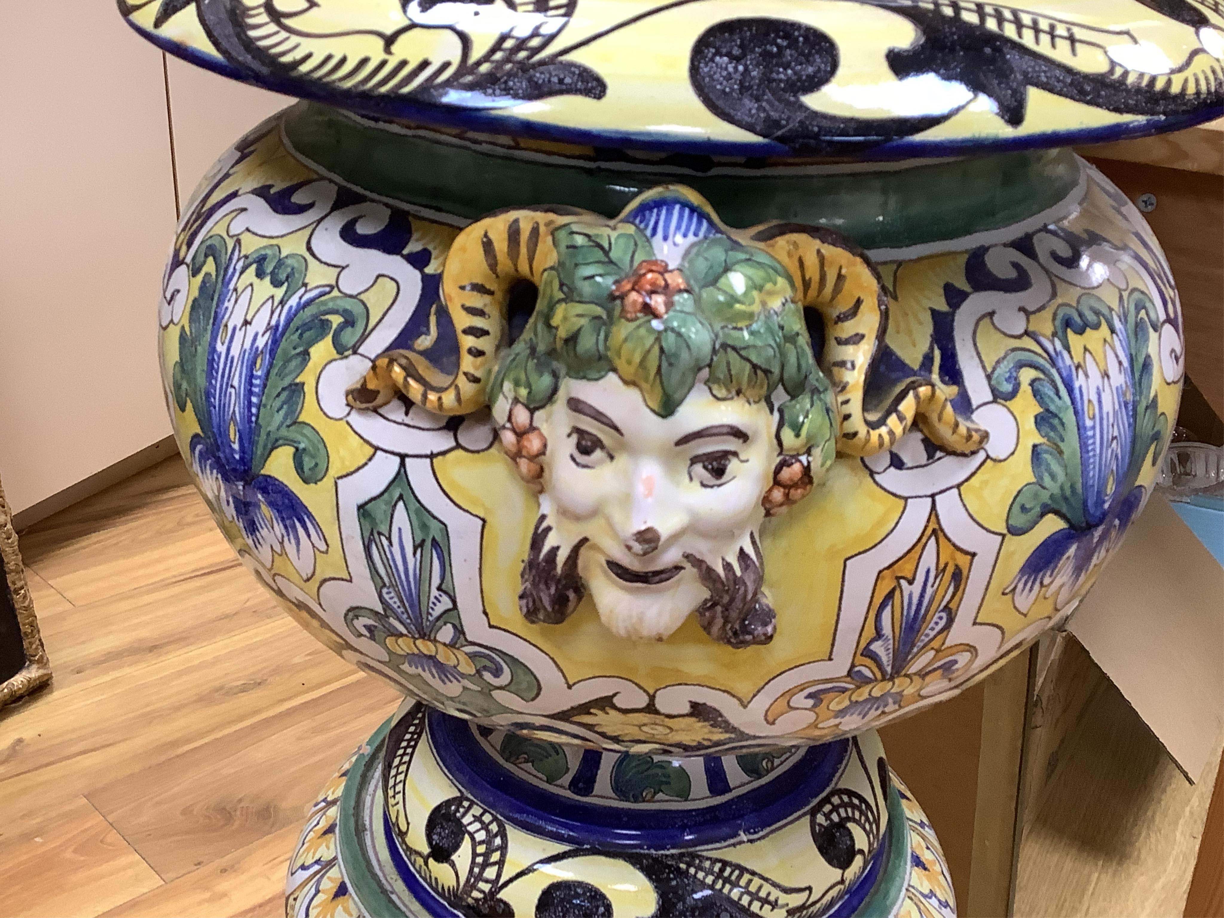 A tall decorative French faience pottery jardiniere with Bacchus mask mounts and a similar associated stand